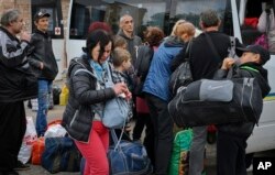 Люди сідають у транспорт під час евакуації з Соледару. Місто було повністю зруйноване в ході бойових дій і з січня 2023 окуповане Росією