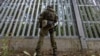 Польский пограничник на польско-белорусской границе перед ограждением. Пункт Половце-Пещатке, Польша, 21 июля 2025 года