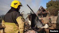 Pompierii intervin la locul loviturii cu rachetă rusească din satul Sknyliv, la periferia orașului Liov, Ucraina, pe 21 august.