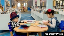 АКШда жашаган Бермет жана Адам Абдишовдор китепканада отурушат.