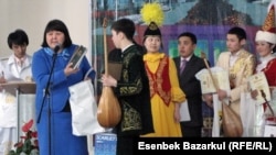 -	Директор регионального научно-практического центра «Астана дарыны»  Майра Курманбаева вручает подарки победителям конкурса школьников-айтыскеров. Астана, 20 марта 2011 года. 