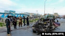 Forțele afgane din Kandahar analizează scena unei explozii a cărei țintă a fost mașina unui comandant al Poliției - 19 aprilie 2021.