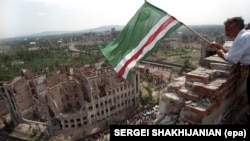 Чеченець із прапором Ічкерії на даху зруйнованого президентського палацу під час святкування четвертої річниці проголошення незалежності, Грозний, 7 вересня 1995 року