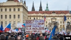 Участники антимусульманской акции держат плакат с надписью на чешском языке: «Остановите ислам и остановите Меркель». Прага, 6 февраля 2016 года.