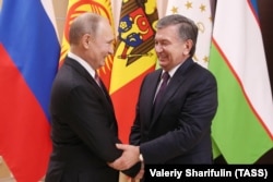 Mirziyoev met with Russian President Vladimir Putin (left) outside Moscow on December 26.