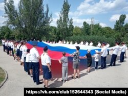 30-метровый флаг России развернули в Симферополе сотрудники крымского главка Следкома РФ в честь Дня России, 12 июня 2025 года