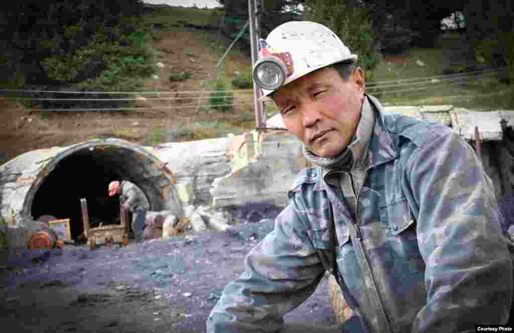 Один из работников на фоне шахты.