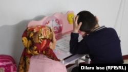 Шарипа Батырбекова, бабушка мальчика, возможно подвергшегося насилию, вместе с внуком, март 2018 года. 