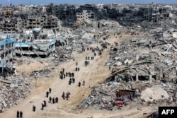 Після припинення вогню люди проходять повз зруйновані будівлі на півночі Сектора Гази, 19 січня 2025 року