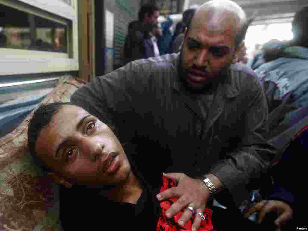 A protester attends to an injured man during clashes in Cairo on January 28.