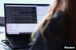 Un angajat al departamentului de securitate cibernetică din echipa mobilă a Jocurilor Olimpice Paris 2024 gestionează un atac cibernetic simulat.