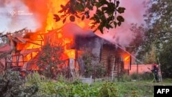 د اوکراین په لویف ښار د روسیې له هوايي برید نه وروسته د اوروژنې مامورین پر یو کور اوبه شیندي - د اګست ۲۱مې انځور
