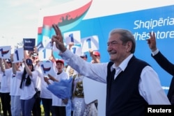 Лидер Демократической партии Сали Бериша машет своим сторонникам во время предвыборного митинга в городе Белш. 1 мая 2025 года