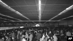 თეირანში, მეგრაბადის აეროპორტი. შაჰის გამგზავრებიდან რამდენიმე დღის შემდეგ, ასობით ადამიანი, მათ შორის, უცხოელები, ირანიდან გაქცევას ცდილობენ. 1979 წლის 25 იანვარი.