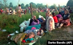 Izbjeglice iz sigurne zone Srebrenica, koje su provele noć na otvorenom, ispred američke baze na aerodromu u Tuzli, 14. juli 1995.