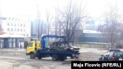 Police remove a burned-out car that they suspect was involved in Oliver Ivanovic's killing.