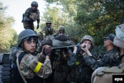 Українські військові несуть пораненого під час бою проти російсько-гібридних сил поблизу Іловайська, 10 серпня 2014 року