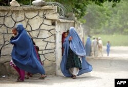 Women scurry for cover as during a international military patrol in eastern Afghanistan.