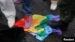 Protesters stand on a rainbow flag during a counterdemonstration outside the Russian parliament following the passing of anti-gay-rights legislation.