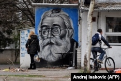 Graffiti pe zidul unei taverne din Belgrad, înfățișându-l pe Karadzic, liderul sârbilor bosniaci în timpul masacrului de la Srebrenița, încă popular în rândul sârbilor ortodocși