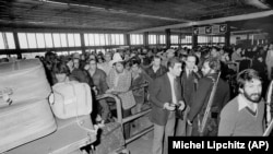 ხომეინის შეირაღებული მომხრეები დარაჯობენ მეჰრაბადის საერთაშორისო აეროპორტს თეირანში, 1979 წლის 18 თებერვალს. შტატების ასობით მოქალაქე ირანიდან გარბის.