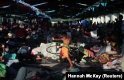 Një migrant, pjesë e karvanit prej mijëra personash që janë nisur nga Amerika Qendrore drejt SHBA-së, luan në një kamp në Juchitan të Meksikës.