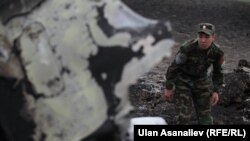 Кыргыз аскерлери кыйраган учактын калдыктарын кароодо. Чүйдүн Панфилов району, 3-май, 2013.