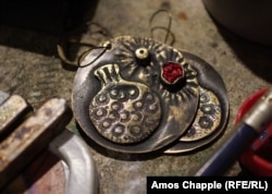 These pomegranate-themed earrings were fashioned from a bullet and autocannon ammunition.