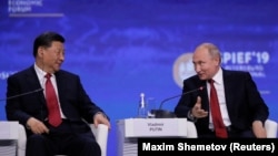 Russian President Vladimir Putin (right) and Chinese President Xi Jinping attend a session of the St. Petersburg International Economic Forum in June 2019.
