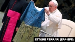 Папа Римський Франциск тримає прапор, який йому привезли з Бучі