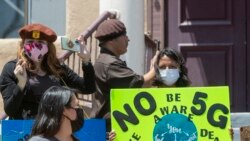 Активісти, які виступають проти запровадження 5G, використовують мобільні телефони на демонстрації, яку вони проводять за підтримки Национальної партії коричневих беретів. Каліфорнія, США