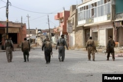 Kurdish Peshmerga forces walk through a town near Mosul after they had retaken it from Islamic State in November.