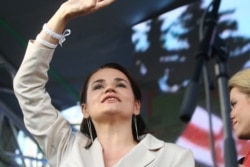 Svyatlana Tsikhanouskaya waves to the crowd at the Minsk rally.