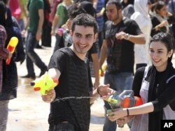 Молодые люди стреляют из водяных пистолетов. Тегеран, 29 июля 2011 года.