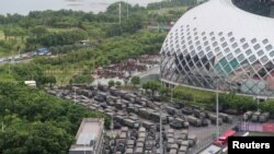 Шеньжень шаарынын стадионунун жанындагы аскерлер жана аскер автоунаалары.