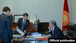 Кыргызстандын мурдагы президенти Алмазбек Атамбаев ошол учурда "Кыргыз темир жолу" ишканасын жетектеп турган Аргынбек Малабаев менен Кытай-Кыргызстан-Өзбекстан темир жолунун багытын талкуулап жаткан учур. 7-январь, 2015-жыл.