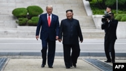 Дональд Трамп в бытность президентом США и лидер Северной Кореи Ким Чен Ын рядом с демаркационной линией, разделяющей Север и Юг. Пханмунджом, 30 июня 2019 года.