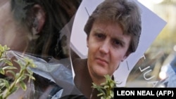 A picture of former Russian spy Aleksandr Litvinenko is pinned to flowers outside the University College Hospital in central London in November 2007.