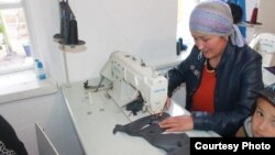 Кийим тигип отурган келин.