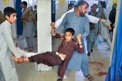 Volunteers carry an injured boy to a hospital following a suicide attack at the funeral of a local police commander in Afghanistan's Nangarhar Province on May 12.