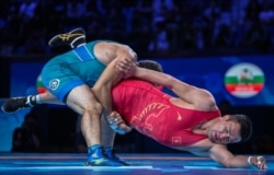 Атабек Азисбеков (кызыл кийимчен) менен өзбек балбаны Рустам Ассакалов Дүйнө чемпионатынын коло байгеси үчүн күрөшүп жаткан учур. Казакстан, Нур-Султан шаары. 16-сентябрь, 2019-жыл.