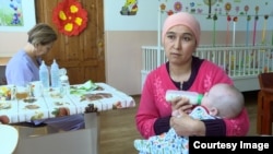Лора Умарова Аселге сүт берип жатат.