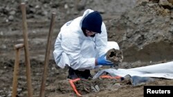 Forenzički stručnjak Međunarodne komisije za nestale osobe (ICMP) traži posmrtne ostatke tokom ekshumacije masovne grobnice u Kozluku, decembar 2015.