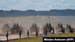 Руски, кинески и монголски трупи и воена опрема парадираат на крајот од воените вежби „Восток-2018“ недалеку од кинеско-монголската граница во Сибир во септември 2018 година.