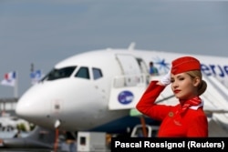 A cabin crew member of Russian carrier Aeroflot poses in front of a Sukhoi Superjet 100 at a photo session at the 51st Paris Air Show in June 2015.