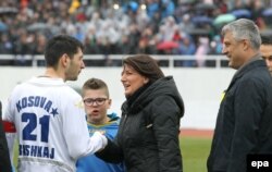 Kapiteni Anel Rashkaj duke përshëndetur presidenten e atëhershme të Kosovës, Atifete Jahjaga, dhe ish-kryeministrin Hashim Thaçi, para ndeshjes së parë ndërkombëtare të Kosovës në futboll, kundër Haitit në Mitrovicë të Jugut, 5 mars 2014.