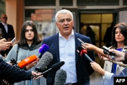 Andrija Mandic, leader of the Democratic Front, speaks to journalists after voting.