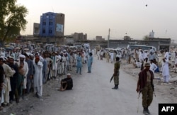 Displaced from North Waziristan gather outside of the World Food Programme (WFP) food distribution point in Bannu, June 24, 2014