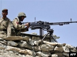 FILE: A Pakistani Army soldiers take position at Sholam Post, a military checkpost overlooking Wana, South Waziristan