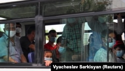 Türkmenistanda, awtobusda maskaly sapar edýän ýolagçylar. Illýustrasiýa suraty